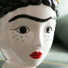Hand-painted ceramic doll vase with floral design"